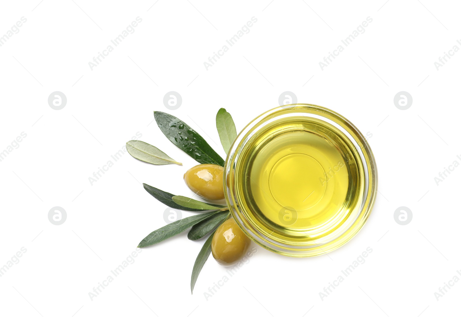 Photo of Little bowl with oil, ripe olives and leaves on white background