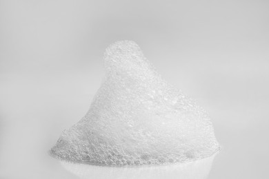 Photo of Drop of fluffy bath foam on light background