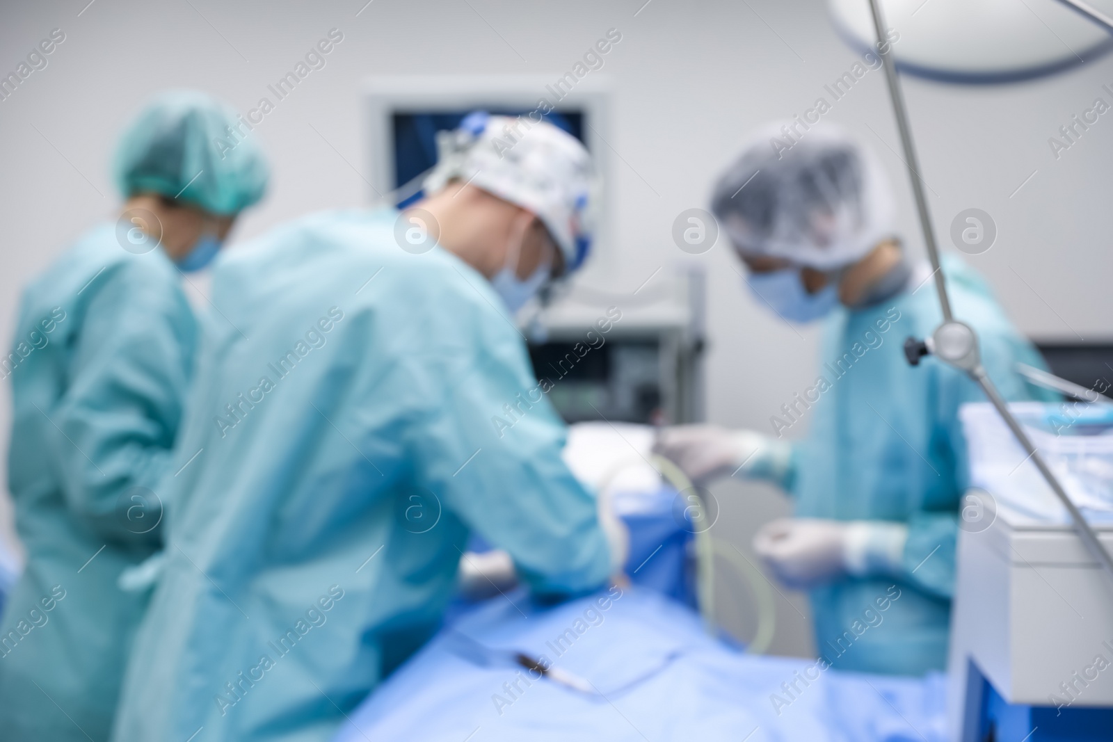 Photo of Blurred view of doctors operating patient in surgery room