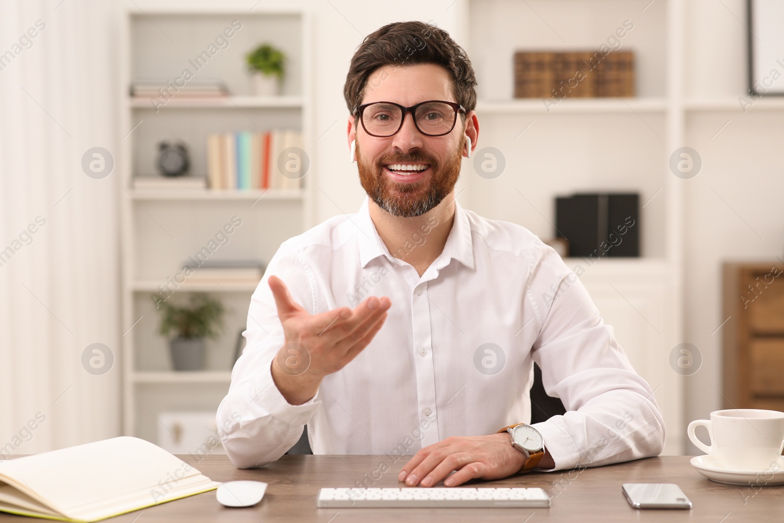 Photo of Happy businessman having online video call at wooden desk indoors, view from web camera