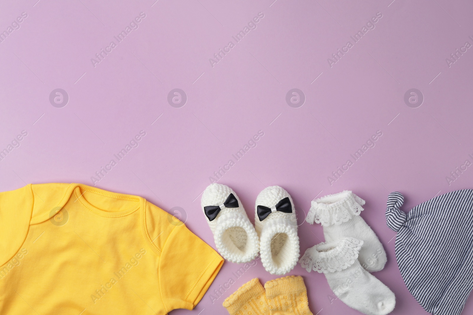 Photo of Flat lay composition with child's clothes on violet background, space for text