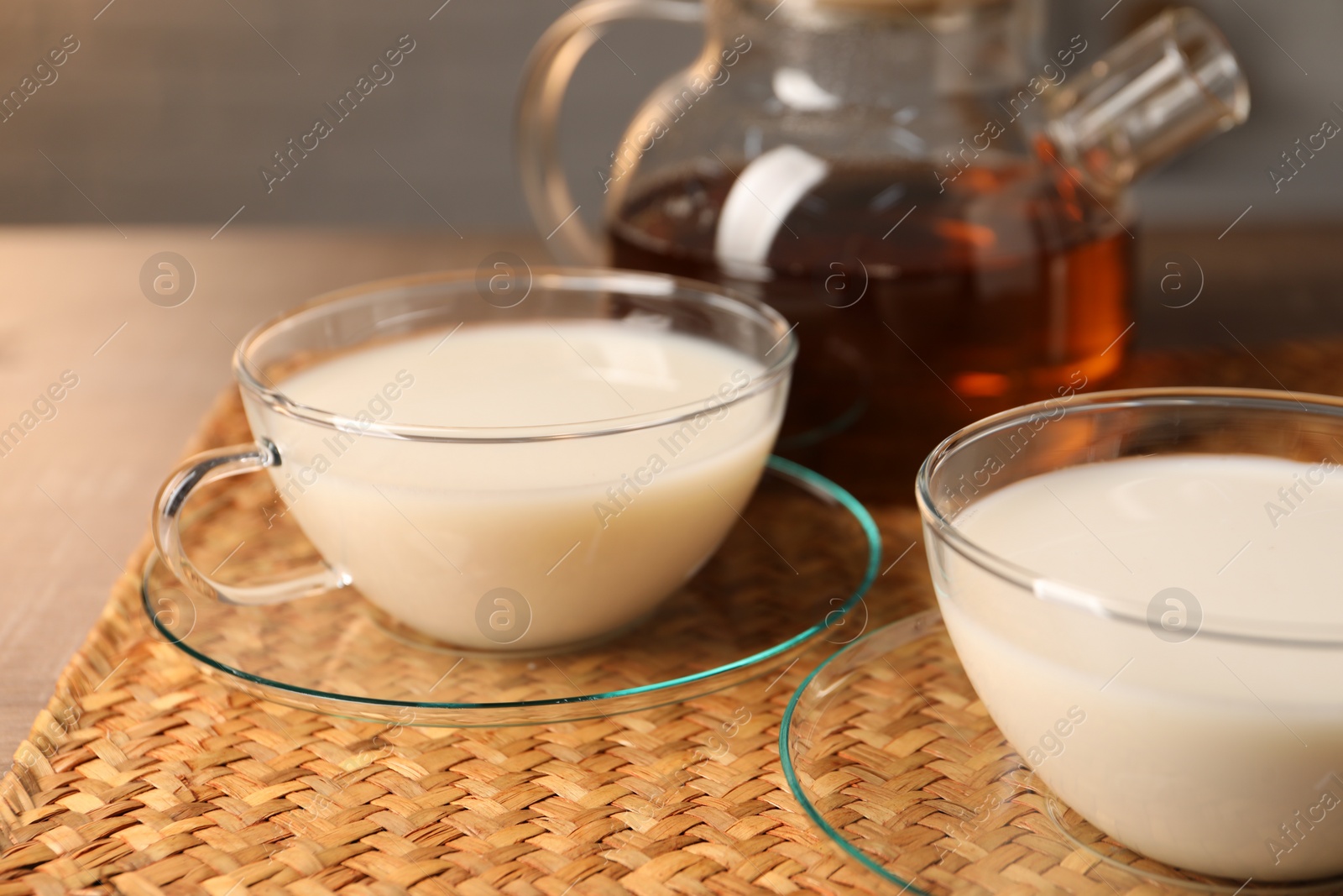 Photo of Tasty milk in glass cups on table, closeup