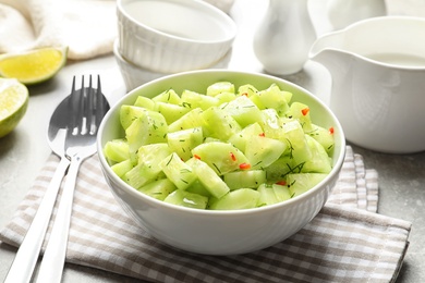 Photo of Delicious cucumber salad in bowl served on table