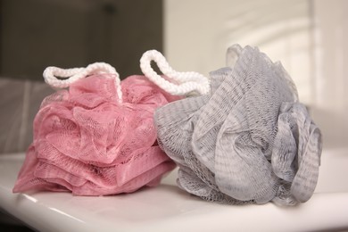 Colorful shower puffs on washbasin in bathroom, closeup