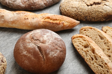 Photo of Different kinds of fresh bread on grey table