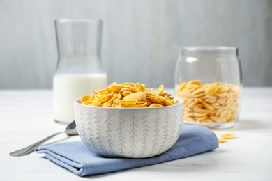 Tasty corn flakes on white wooden table