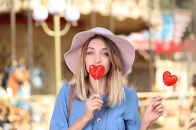 Beautiful woman with candies having fun at amusement park