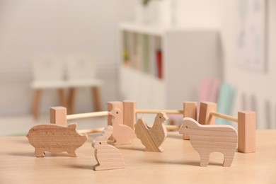 Wooden animals and fence on table indoors. Children's toys