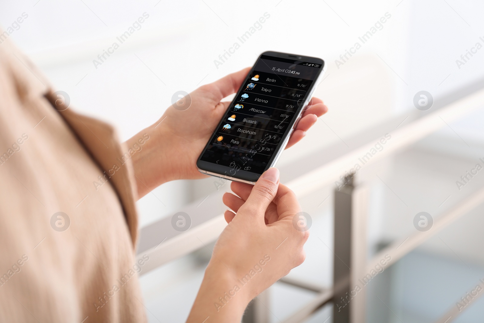 Image of Woman using weather forecast app on smartphone indoors, closeup