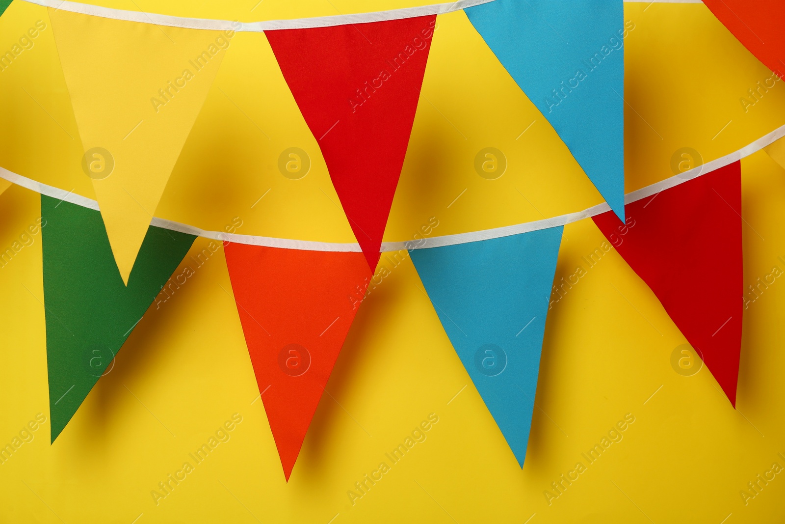 Photo of Buntings with colorful triangular flags on yellow background