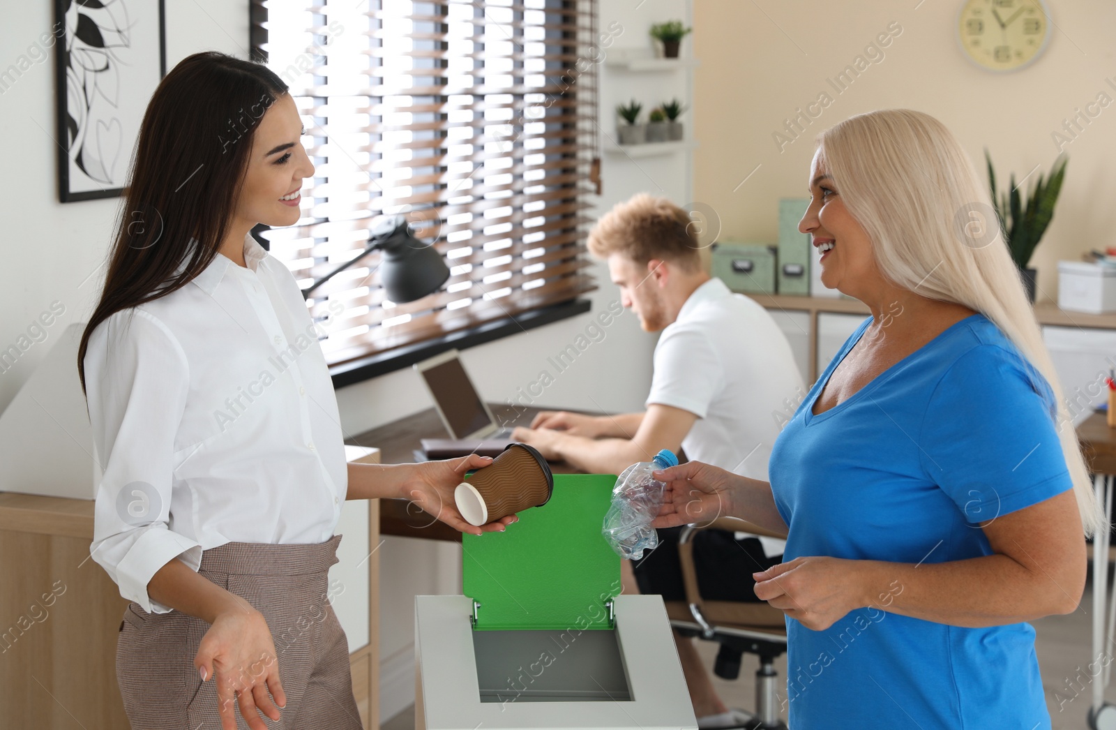 Photo of Women with garbage at recycling bin in office