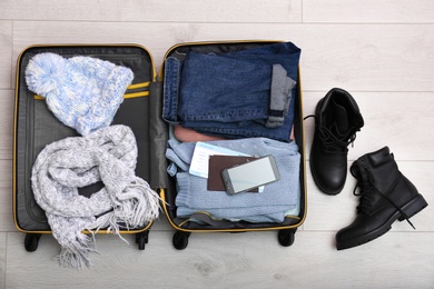 Packed suitcase on wooden background, top view