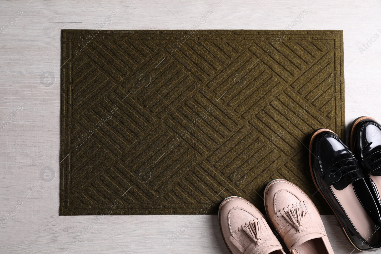 Photo of New clean door mat and shoes on floor, flat lay