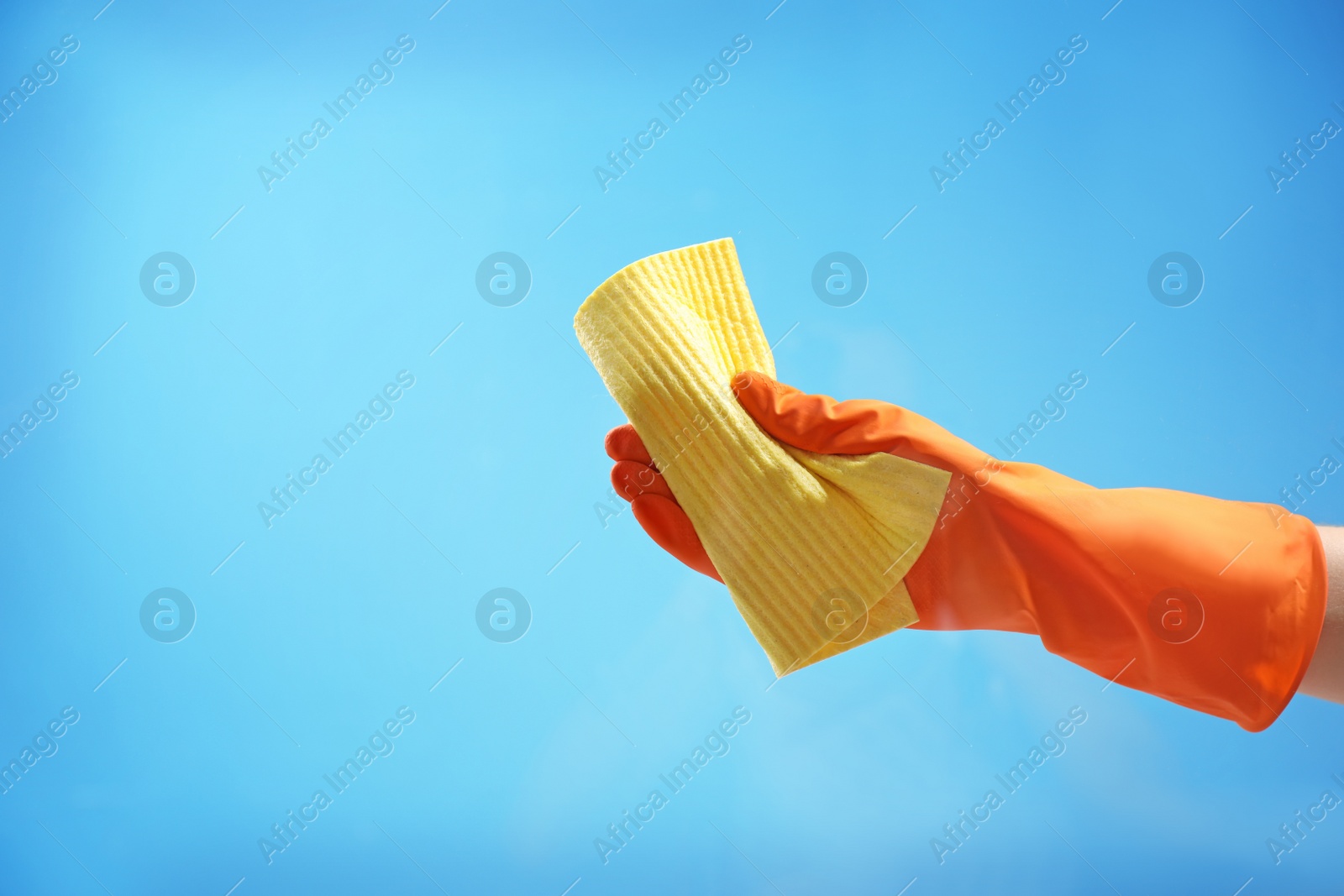 Photo of Woman cleaning glass against color background