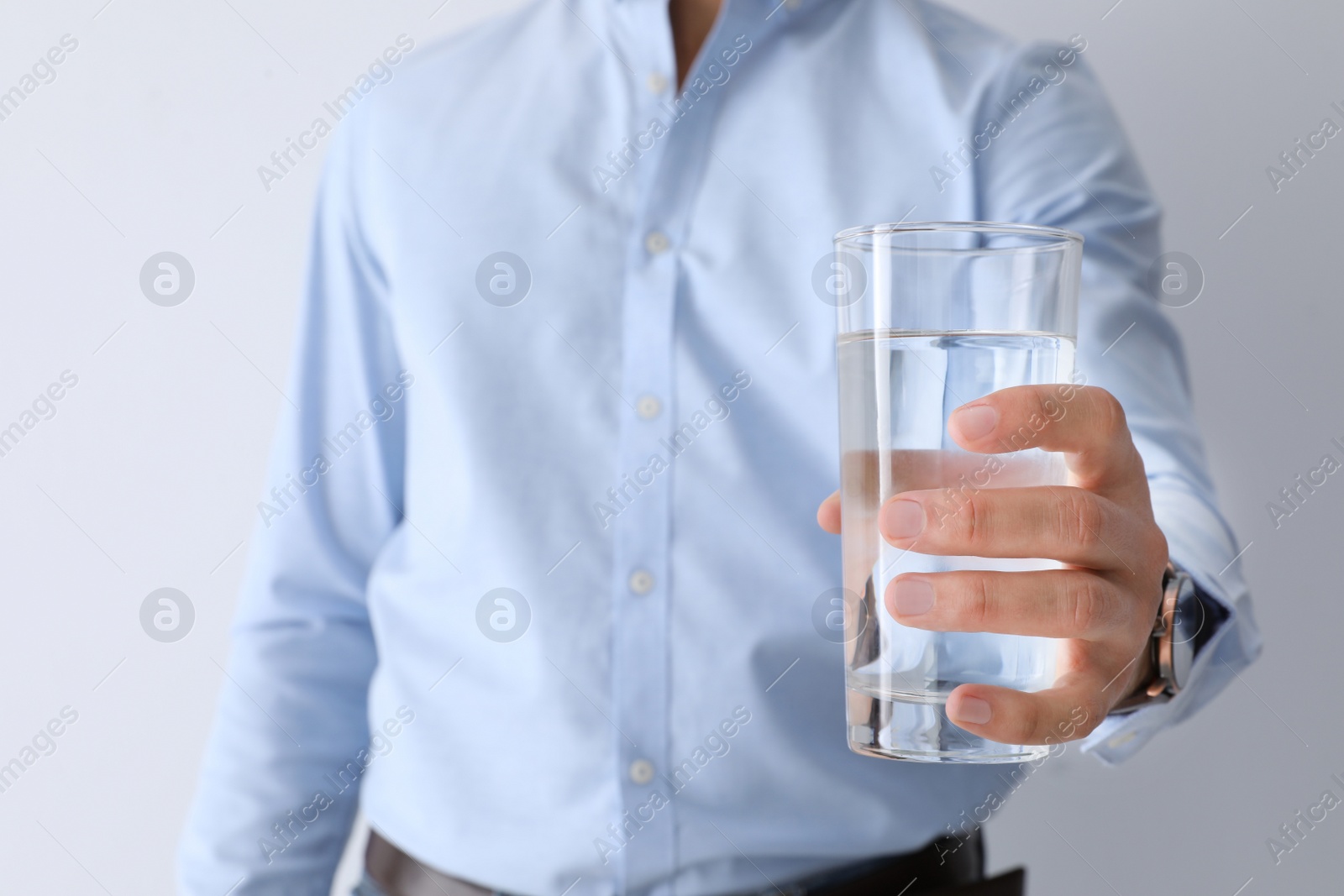 Photo of Man holding glass of pure water on white background, closeup