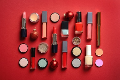 Flat lay composition with makeup products and Christmas decor on color background