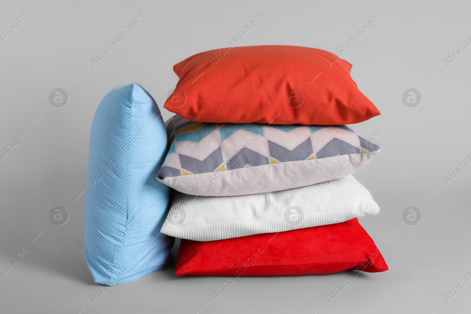 Photo of Different stylish soft pillows on grey background