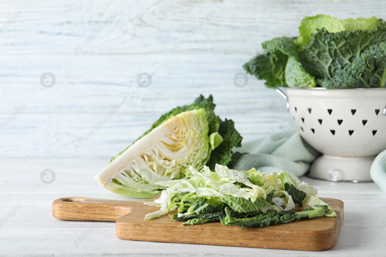 Photo of Cut fresh savoy cabbage on white wooden table