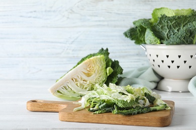 Cut fresh savoy cabbage on white wooden table