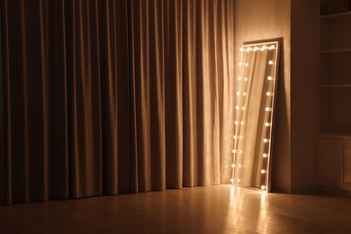 Photo of Modern mirror with light bulbs in makeup room