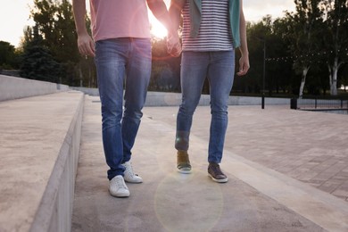 Photo of Gay couple walking outdoors on sunny day, closeup