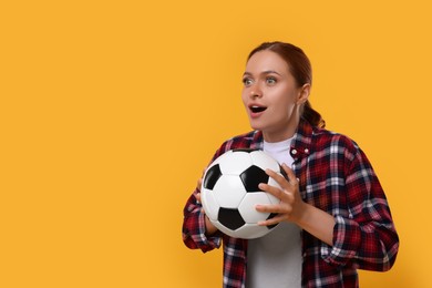 Photo of Emotional fan holding football ball on yellow background, space for text