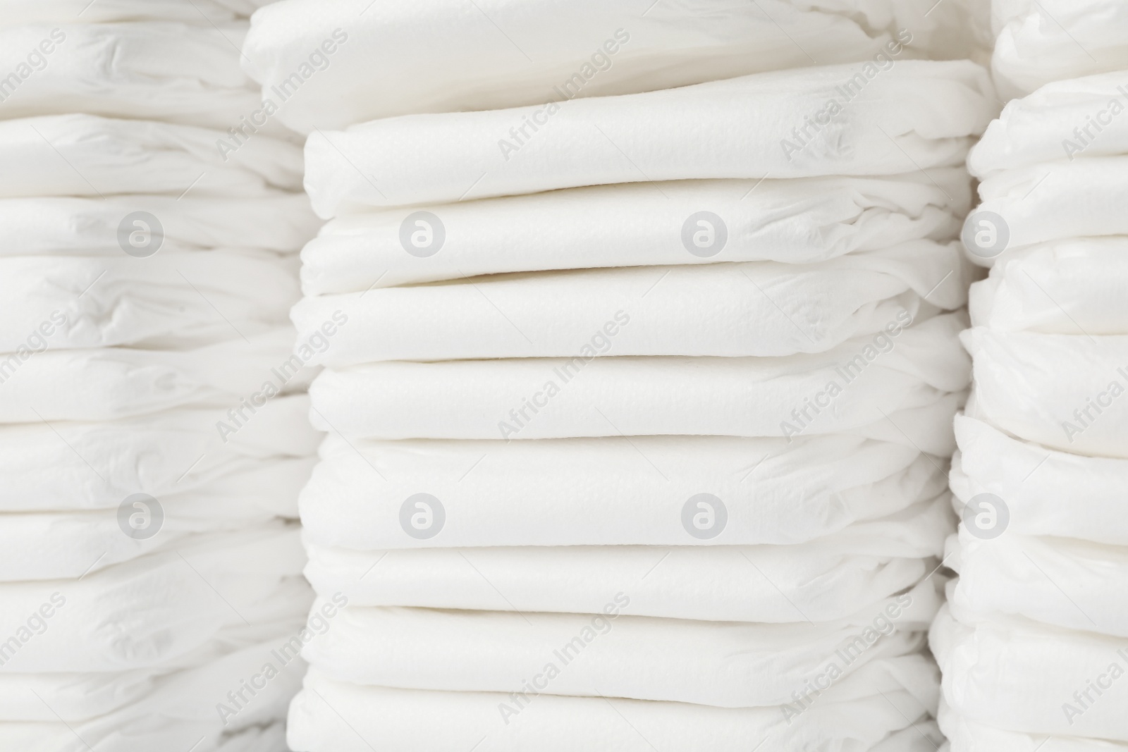 Photo of Stacks of baby diapers as background, closeup