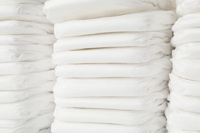 Photo of Stacks of baby diapers as background, closeup