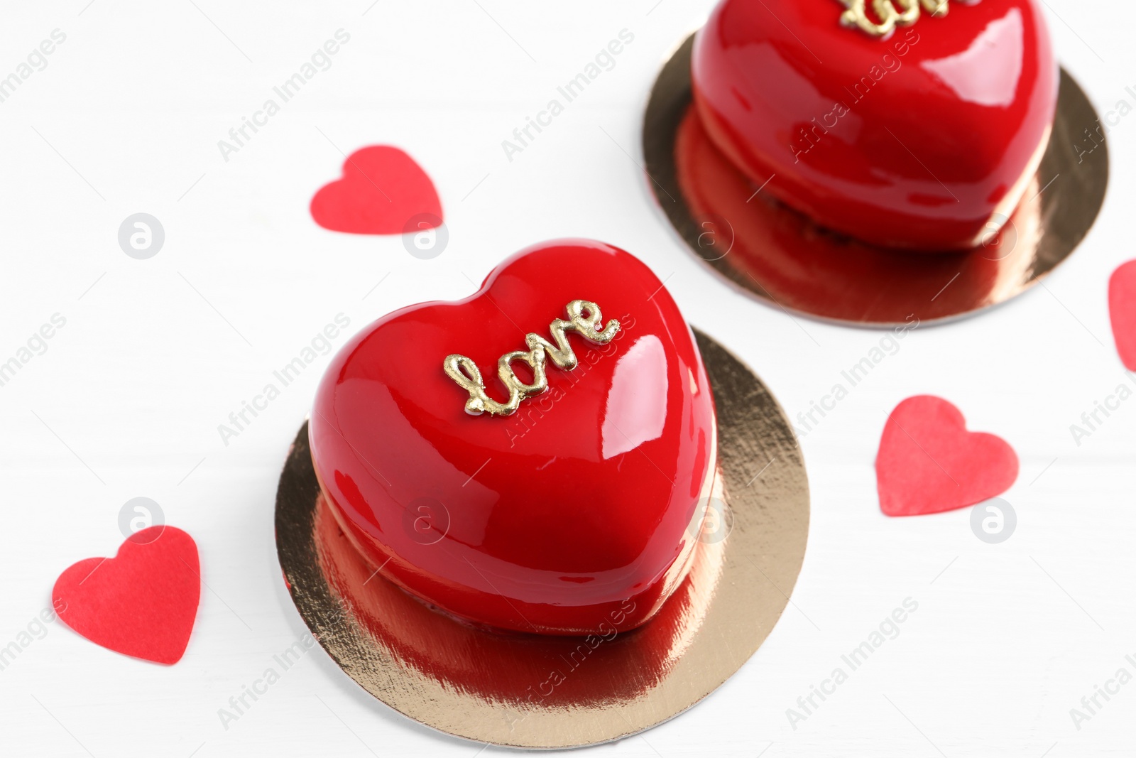 Photo of St. Valentine's Day. Delicious heart shaped cakes and confetti on white wooden table, closeup