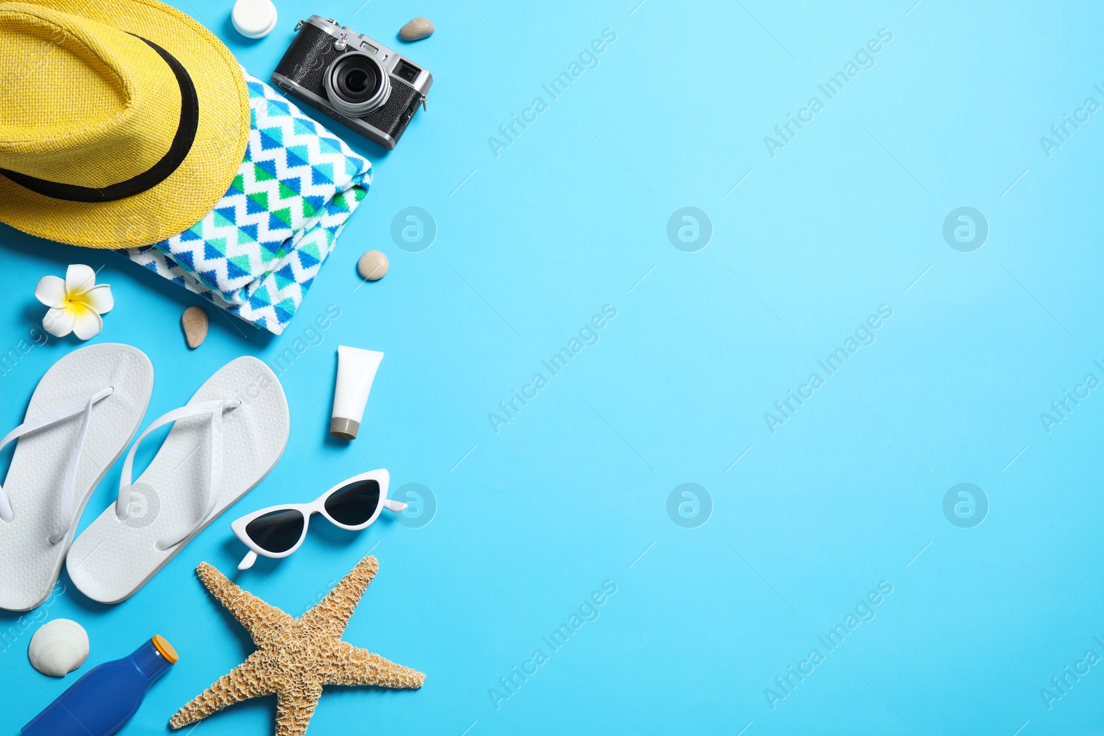 Photo of Flat lay composition with stylish beach accessories on light blue background, space for text