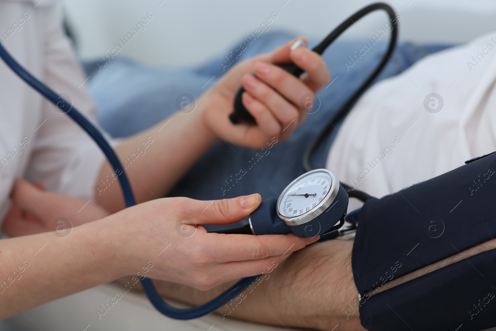 Photo of Doctor checking blood pressure of man in clinic, closeup