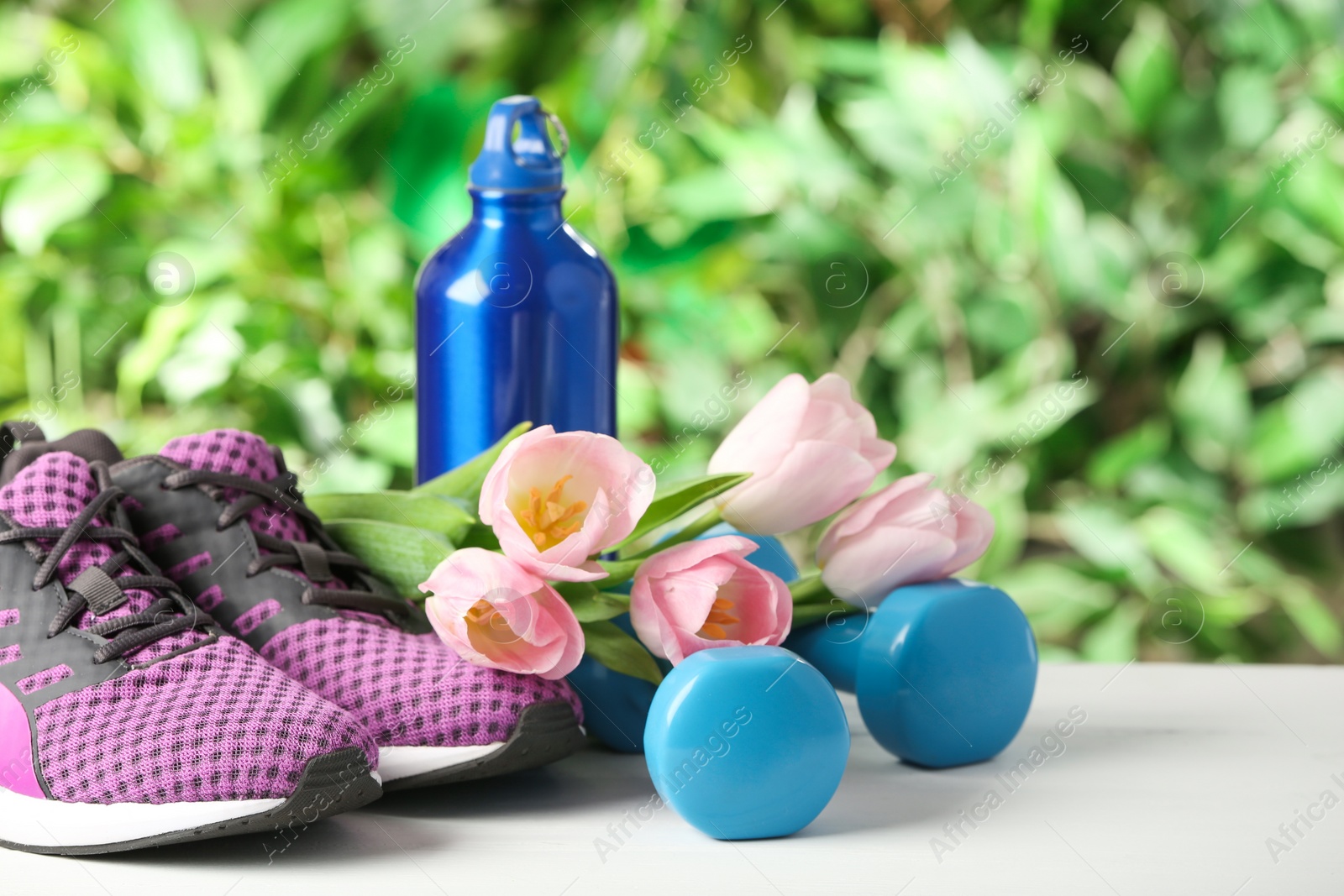 Photo of Composition with spring flowers and sports items on blurred green background