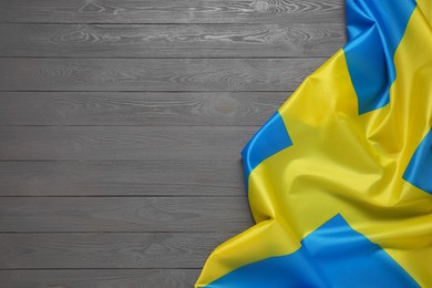 Photo of Flag of Sweden on gray wooden background, top view. Space for text