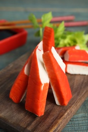 Fresh crab sticks served on wooden board, closeup