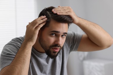 Man with dandruff in his dark hair indoors