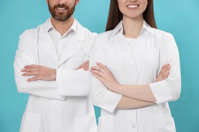 Photo of Nurses in medical uniform on light blue background, closeup