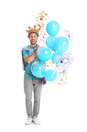 Young man with crown and air balloons on white background