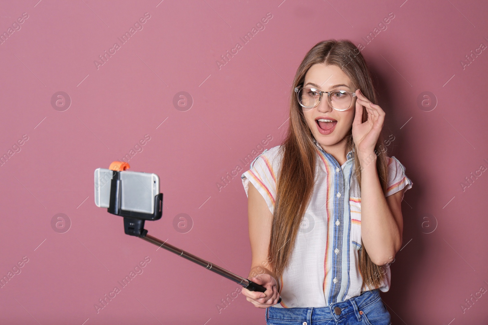 Photo of Young beautiful woman taking selfie against color background