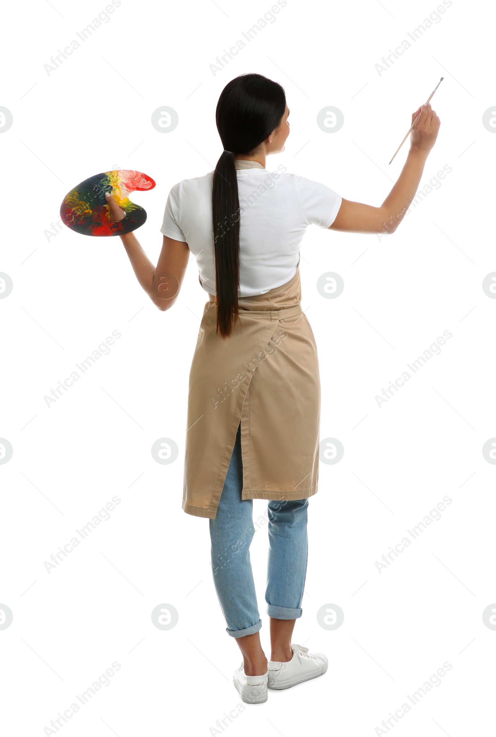 Photo of Young woman drawing with brush on white background, back view