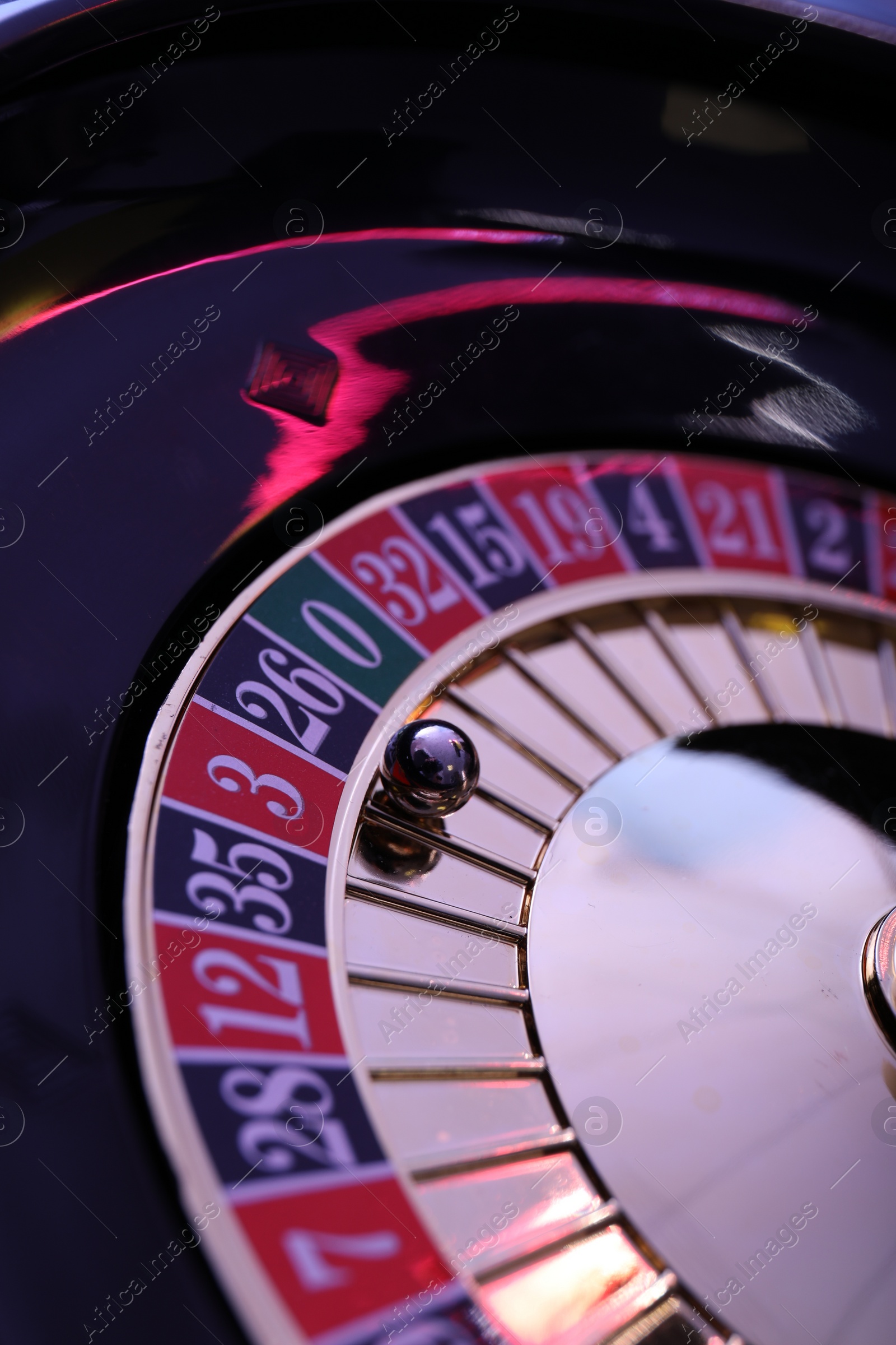 Photo of Roulette wheel with ball, closeup. Casino game