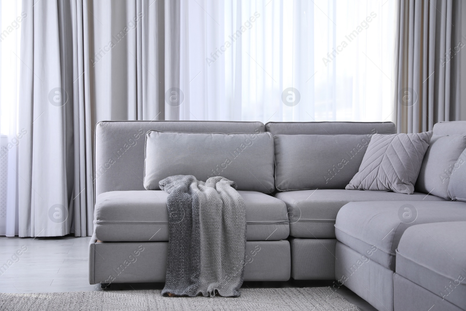 Photo of Large grey sofa in living room. Interior design