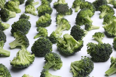 Many fresh green broccoli pieces on white background, closeup