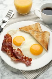 Photo of Delicious breakfast with sunny side up eggs served on white marble table, closeup