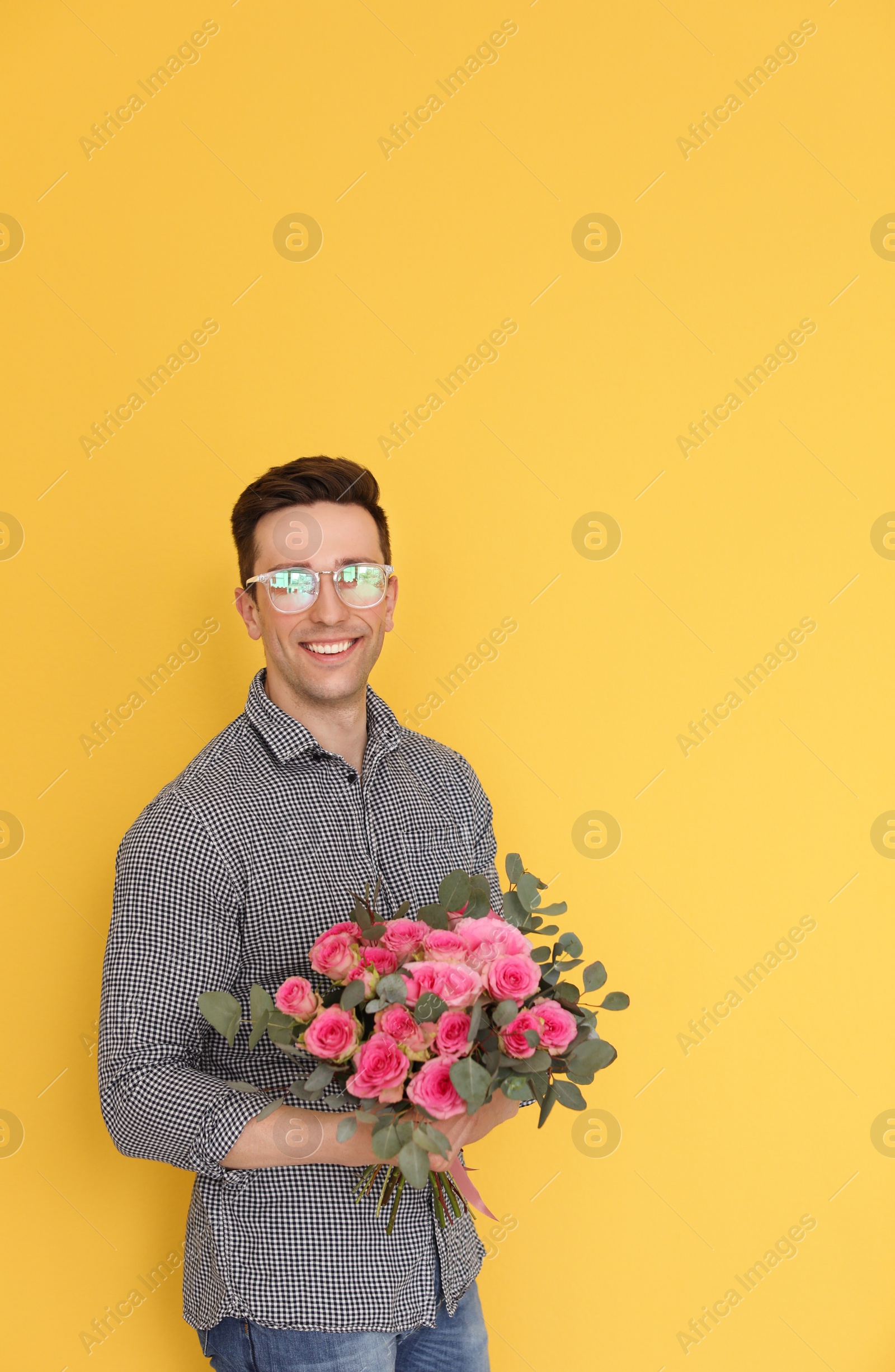 Photo of Male florist holding bouquet of beautiful flowers on color background