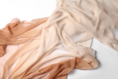 Beautiful beige tulle fabric on white background, top view