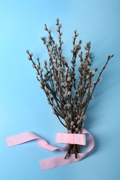 Photo of Beautiful blooming willow branches on light blue background