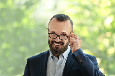 Portrait of handsome mature man in elegant suit near window