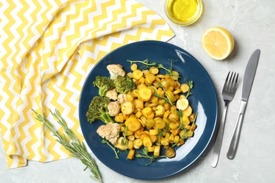 Photo of Tasty baked yellow carrot with broccoli, cauliflowers and pea sprouts served on light grey marble table, flat lay