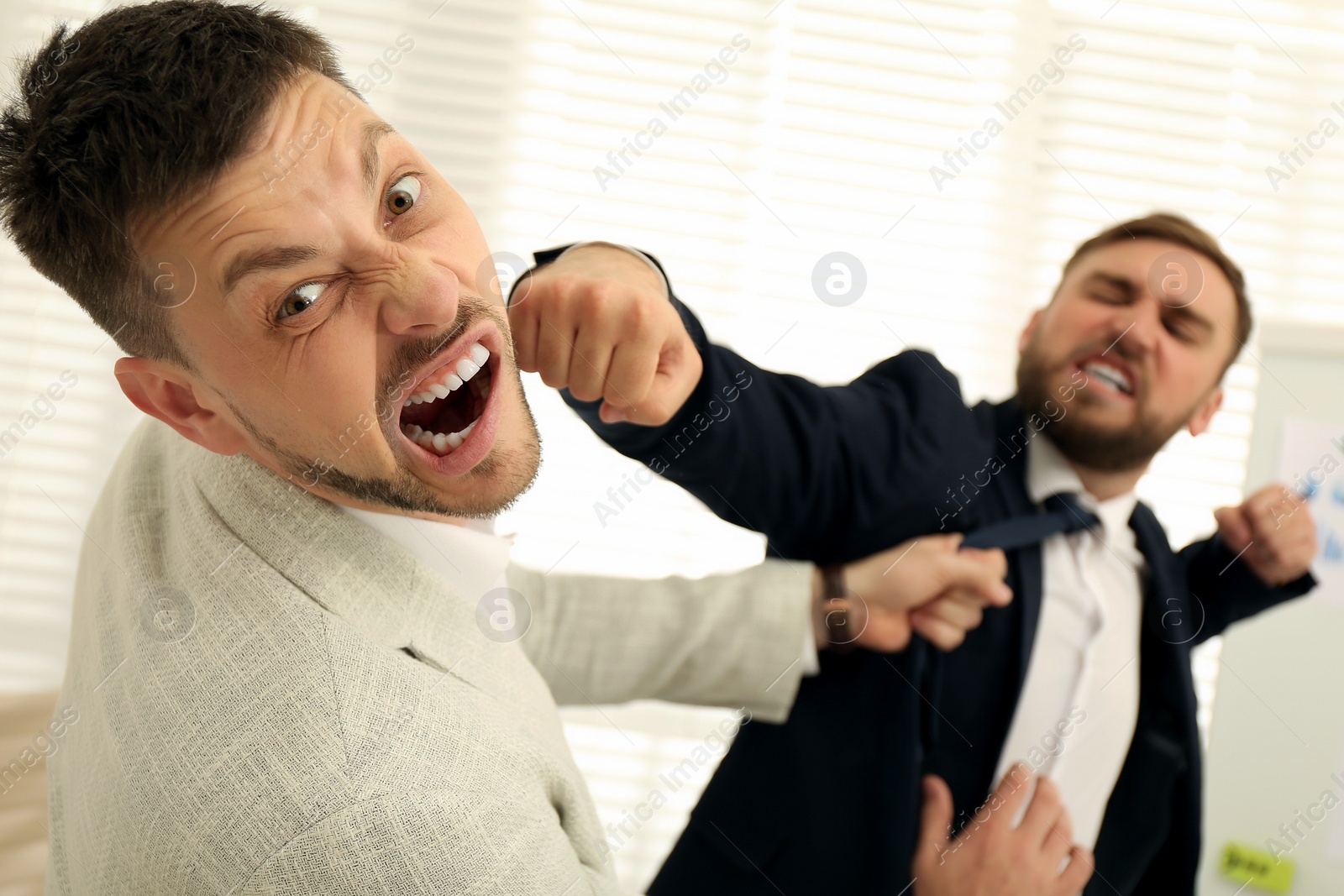 Photo of Emotional colleagues fighting in office. Workplace conflict