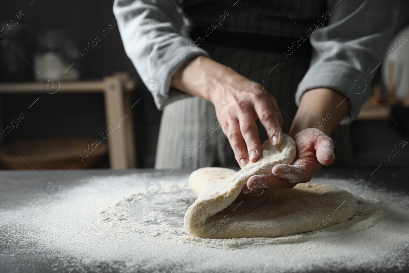 Photo of Woman making pizza dough at table, closeup